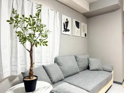 a living room with a couch and a potted tree at Roppongi 3min Walk, Shinjuku 10min,Shibuya 15min, Tokyo Tower 58sqm for 6 in Tokyo