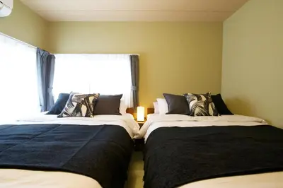 two beds in a room with a window at Realization INN Horikiri in Tokyo