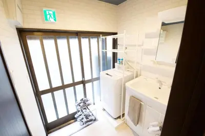 a bathroom with a sink and a toilet and a mirror at Realization INN Horikiri in Tokyo