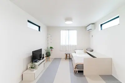 a white living room with a bed and a tv at New decorative 6ppl 3-Story House 5-mins walk Sta in Tokyo