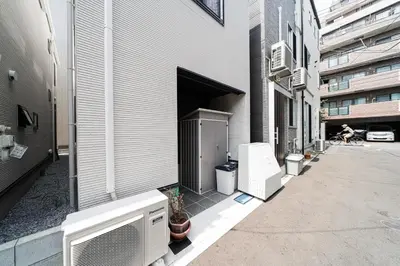 a building with a door open and a person sitting in a chair at New decorative 6ppl 3-Story House 5-mins walk Sta in Tokyo