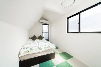 a bedroom with a bed in a room with a checkered floor at New decorative 6ppl 3-Story House 5-mins walk Sta in Tokyo