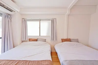 two beds in a room with a window at V Close to Shinjuku Kabukicho Korean Town FrWIFI B in Tokyo