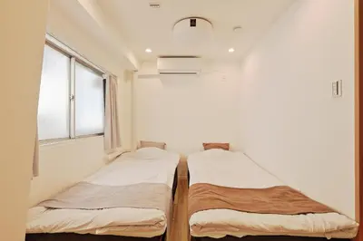 two beds in a room with a window at V Close to Shinjuku Kabukicho Korean Town FrWIFI B in Tokyo