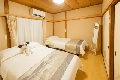 a hotel room with two beds with a stuffed animal on them at Mie's House Skytree 美英軒 in Tokyo