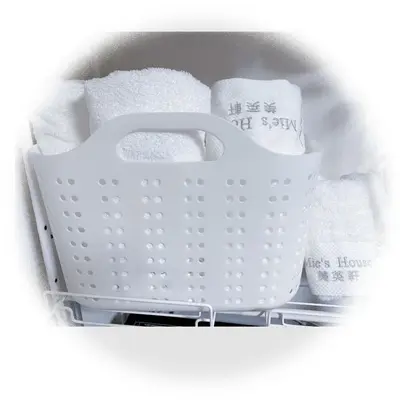 a white basket sitting on a shelf with towels at Mie's House Skytree 美英軒 in Tokyo