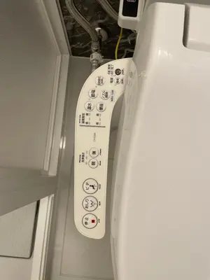 a remote control attached to a toilet in a room at Mie's House Skytree 美英軒 in Tokyo