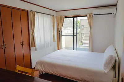 a bedroom with a bed and a large window at Akira Hiro House in Tokyo