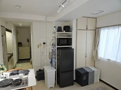 a kitchen with a black refrigerator and a table at \u30db\u30c6\u30eb\u30ec\u30b9\u30dd\u30ef\u30fc\u30eb401 in Tokyo