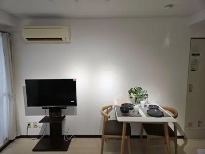 a living room with a television and a table with chairs at \u30db\u30c6\u30eb\u30ec\u30b9\u30dd\u30ef\u30fc\u30eb401 in Tokyo