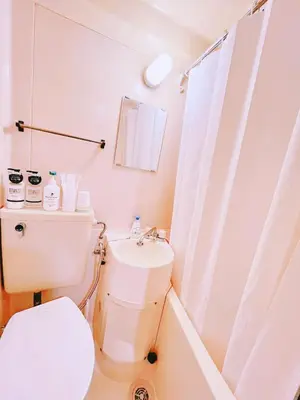 a white bathroom with a toilet and a sink at M-house in Tokyo