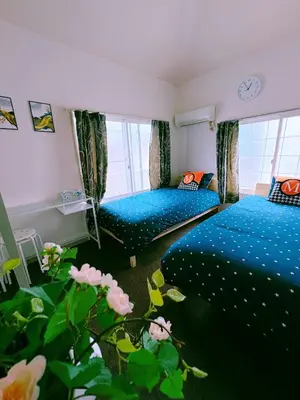a bedroom with two twin beds and a clock on the wall at M-house in Tokyo