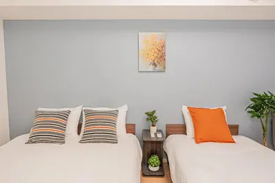 two beds sitting next to each other in a bedroom at 101 6-min walk from Higashi-Jūjō Station Cozy 1-Bedroom Apartment Direct Access to Akihabara & Ueno in Tokyo