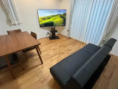 a living room with a table and a tv on the wall at YOYOGIHOUSE - Vacation STAY 19984 in Tokyo