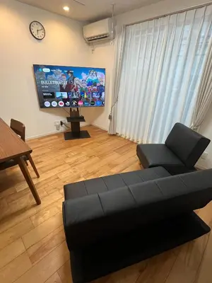 a living room with a couch and a flat screen tv at YOYOGIHOUSE - Vacation STAY 19984 in Tokyo
