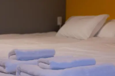 a pile of towels sitting on a bed at ECORO Shinjuku Dai2 Building 2F - Vacation STAY 20114 in Tokyo