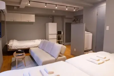 a living room with two beds and a couch at ECORO Shinjuku Dai2 Building 2F - Vacation STAY 20114 in Tokyo