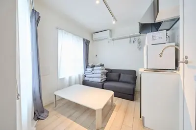 a small living room with a couch and a refrigerator at 12 \u3068\u308a\u3063\u3071\u30fc\u305a\u30db\u30c6\u30eb\u9ad8\u7530\u99ac\u5834 in Tokyo