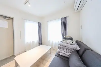 a living room with a couch and some windows at 12 \u3068\u308a\u3063\u3071\u30fc\u305a\u30db\u30c6\u30eb\u9ad8\u7530\u99ac\u5834 in Tokyo