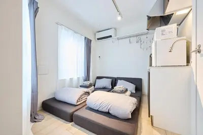 a living room with a couch and a refrigerator at 12 \u3068\u308a\u3063\u3071\u30fc\u305a\u30db\u30c6\u30eb\u9ad8\u7530\u99ac\u5834 in Tokyo