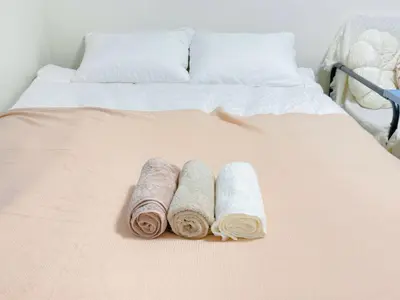 two rolled towels sitting on top of a bed at TD House 3-min Walk Easy Access Shinjuku, Shibuya, Asakusa, Ueno in Tokyo