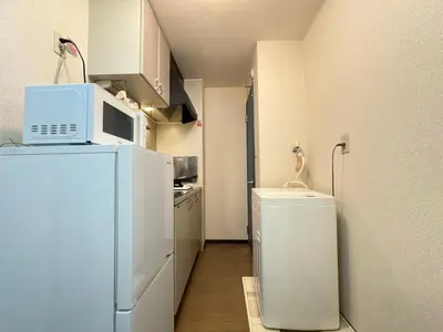 a small kitchen with a microwave on top of a refrigerator at TD House 3-min Walk Easy Access Shinjuku, Shibuya, Asakusa, Ueno in Tokyo