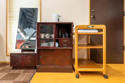 an old wooden cabinet with a shelf next to a door at SHINJUKU Garden-house in Tokyo