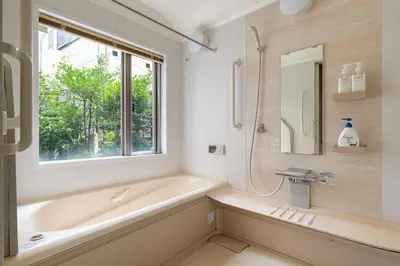 a bathroom with a tub and a sink and a window at SHINJUKU Garden-house in Tokyo