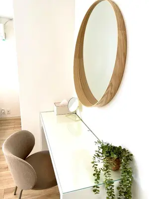 a mirror hanging on a wall next to a table and a chair at Sakura Stays Tokyo - Stay Together with Privacy - Ideal Group Accommodation in Tokyo