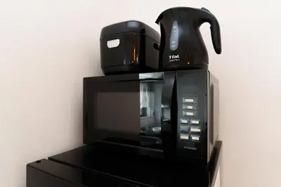 a microwave with a coffee pot on top of it at Sakura Stays Tokyo - Stay Together with Privacy - Ideal Group Accommodation in Tokyo