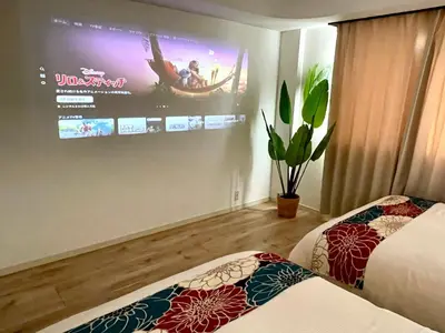 a room with two beds and a tv on the wall at Sakura Stays Tokyo - Stay Together with Privacy - Ideal Group Accommodation in Tokyo