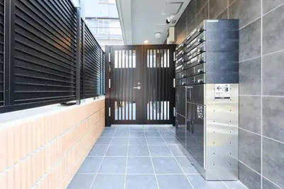 a hallway of a building with black doors and tiles at 31 \u3068\u308a\u3063\u3071\u30fc\u305a\u30db\u30c6\u30eb\u9ad8\u7530\u99ac\u5834 in Tokyo