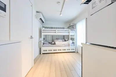 a small white bedroom with a bunk bed in it at 31 \u3068\u308a\u3063\u3071\u30fc\u305a\u30db\u30c6\u30eb\u9ad8\u7530\u99ac\u5834 in Tokyo