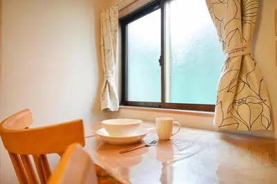 a table with a cup and a plate on it with a window at Roseheim 2 kamiochiai in Tokyo