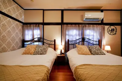 two beds in a bedroom with two lamps and curtains at Roseheim 2 kamiochiai in Tokyo