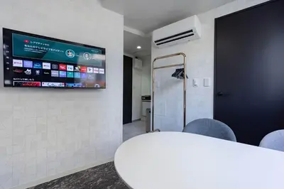 a room with a table and a tv on a wall at KOKOON Hotel Shibuya 201 in Tokyo