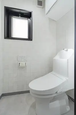 a white bathroom with a toilet and a window at KOKOON Hotel Shibuya 201 in Tokyo