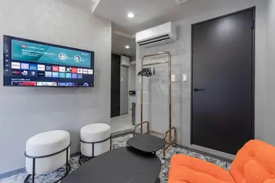 a waiting room with a tv and two stools at KOKOON Hotel Shibuya 301 in Tokyo