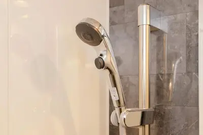 a shower with a shower head in a bathroom at KOKOON Hotel Shibuya 301 in Tokyo