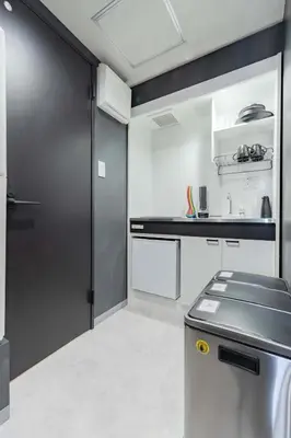a kitchen with a black door and white cabinets at KOKOON Hotel Shibuya 401 in Tokyo
