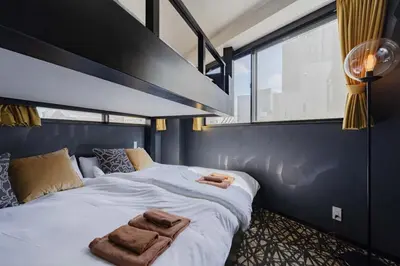 a bedroom with a large bed with two towels on it at KOKOON Hotel Shibuya 401 in Tokyo