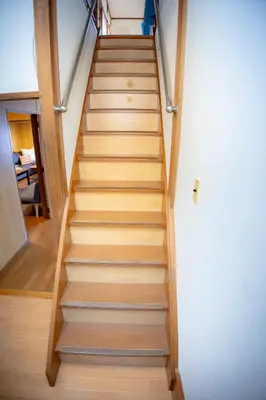 a staircase in a house with wooden rails at Voyager Inn in Tokyo