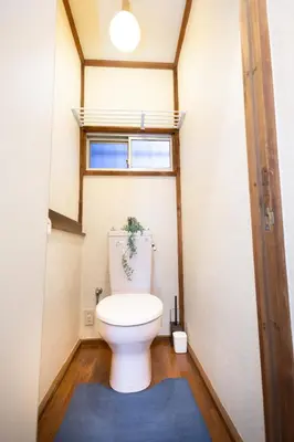 a toilet in a small bathroom with a window at Voyager Inn in Tokyo