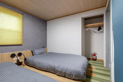 a bedroom with two beds and a window at CHOCKY Nishi-Shinjuku in Tokyo