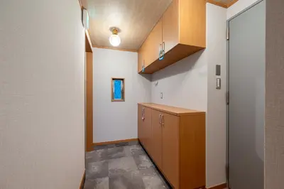 a kitchen with white walls and wooden cabinets at CHOCKY Nishi-Shinjuku in Tokyo