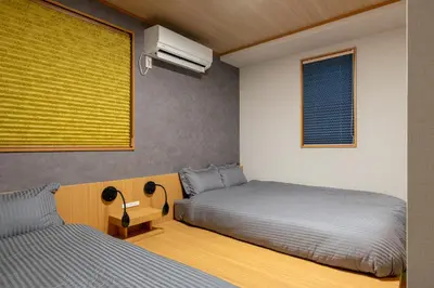 a bedroom with two beds and a window at CHOCKY Nishi-Shinjuku in Tokyo