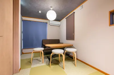 a small room with a table and two stools at CHOCKY Nishi-Shinjuku in Tokyo