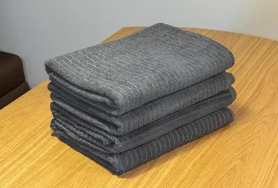 a stack of gray towels sitting on a table at CHOCKY Nishi-Shinjuku in Tokyo