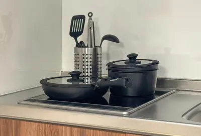a kitchen counter with a pot and utensils on a sink at CHOCKY Nishi-Shinjuku in Tokyo