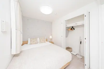 a white bedroom with a bed and a window at \u30eb\u30eb\u30df\u30a8\u30fc\u30eb\u4e21\u56fd in Tokyo